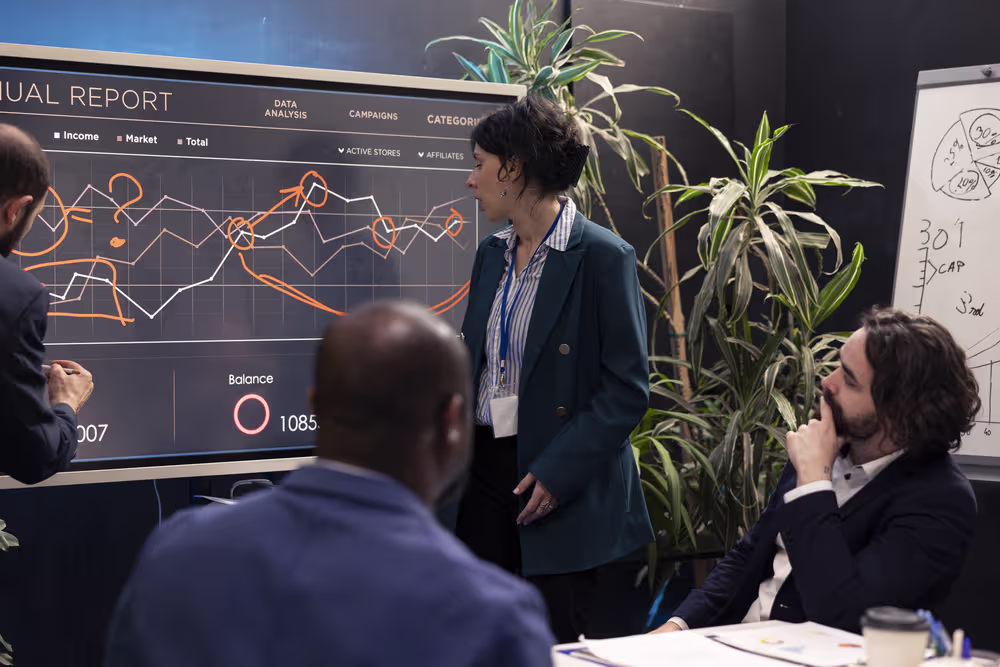 A woman presents an annual report to colleagues in a meeting room, highlighting the reliability of the fully managed IT support it provides.