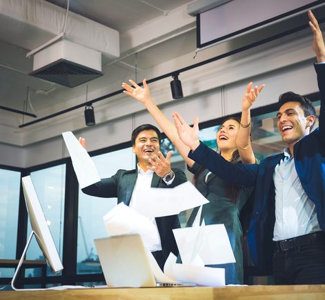 Colleagues celebrating with raised arms in an office, illustrating relief after resolving user access and permission issues